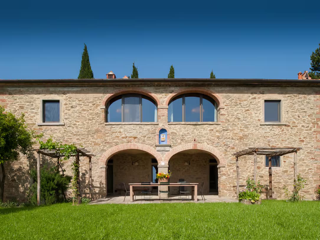 Fachada de piedra de la villa, con sus arcos